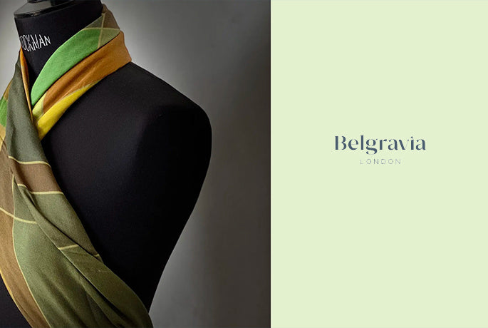 Belgravia website logo on mint green backgound on the right, image of alba amicorum scarf on dress form on the right