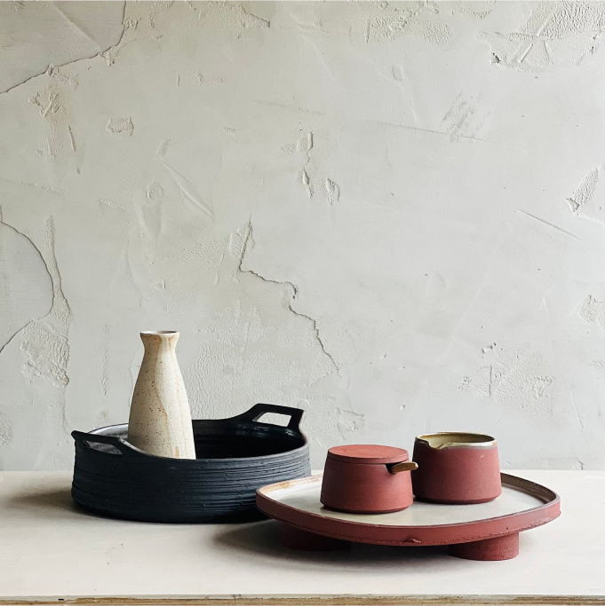 Alex Gabriel ceramics, black handled tray with white vase, terracotta platter with two small terracotta vessels