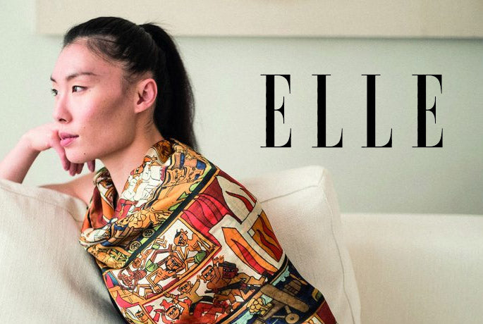 Woman in profile gazing into a warm light, wearing Indian Carousel Scarf by Babuji Rajendra Shilpi - from Alba Amicorum, with the Elle magazine logo superimposed