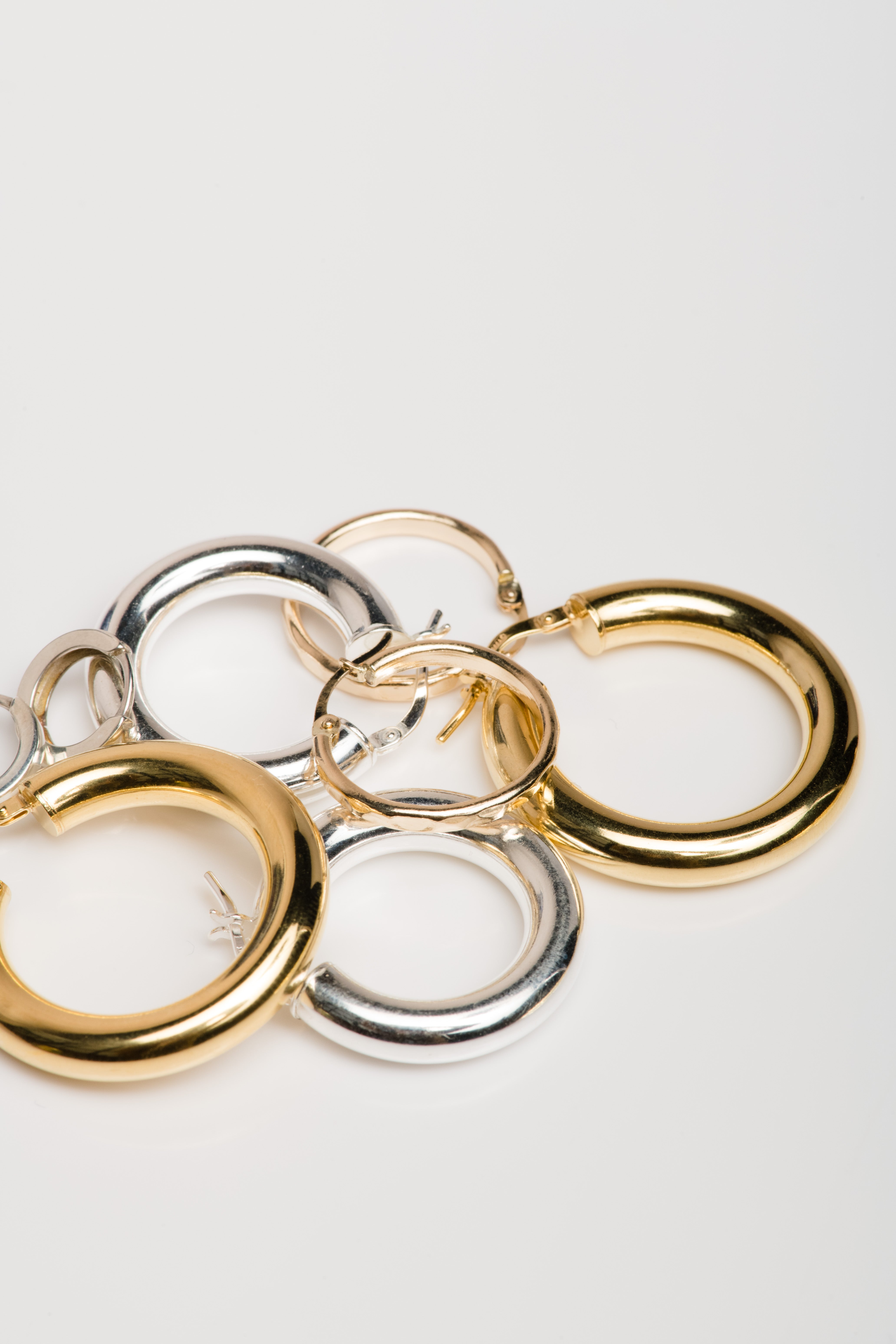 Silver and gold hoop earrings on a white background.