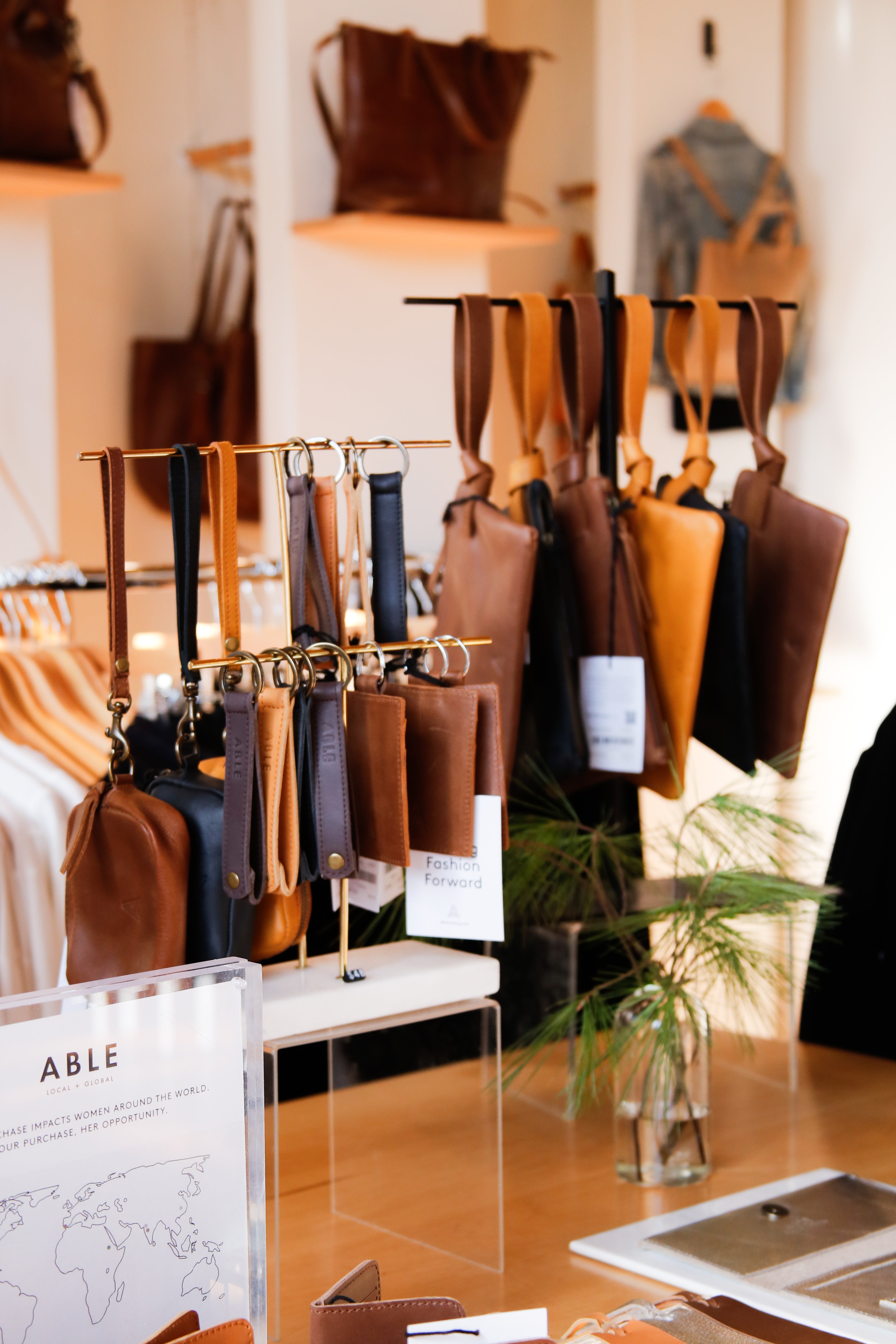 Leather bags and accessories displayed in a boutique store interior.