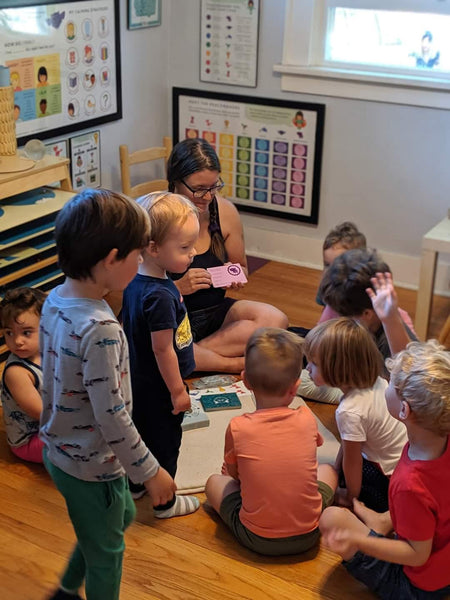 Children and teacher playing with PeaceMakers cards