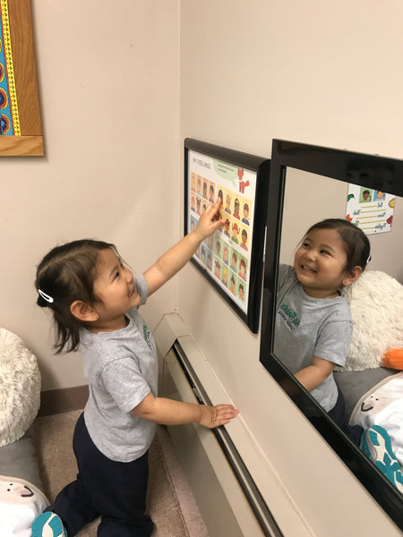 Young girl pointing to her feelings on a Feelings Poster