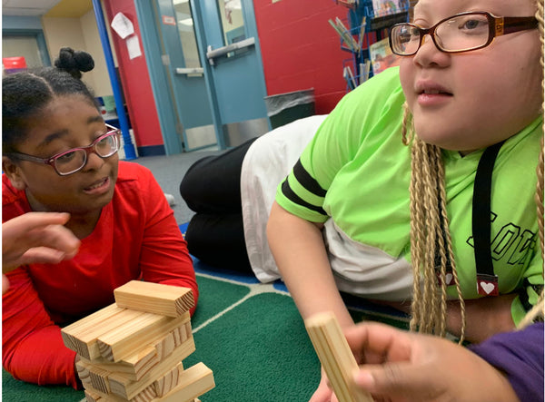Sierra and a peer participate in “Yoga Jenga,” an activity that facilitates social-emotional inclusive practices and mind-body awareness.