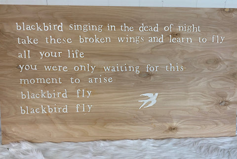 Wood sign with words and bird castings