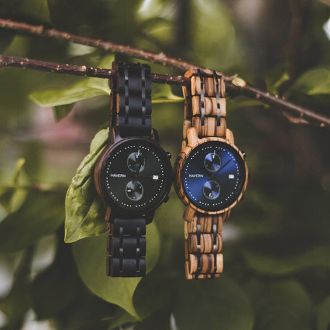 two wooden watches hanging from a tree branch