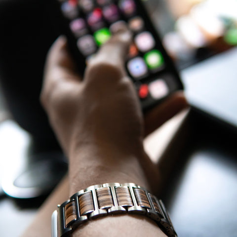 apple watch band on mens wrist holding phone