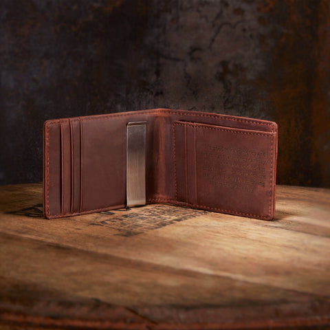 engraved leather wallet on wooden whiskey barrel