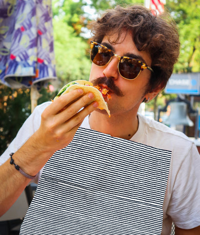 Man eating a taco wearing a blue ticking NEATsheet.