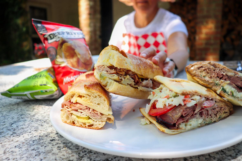 A woman wearing a Red and White Diamond NEATsheet reaching for a sandwich at a picnic.