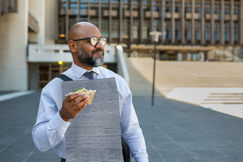 Businessman walking with a sandwich and wearing a NEATsheet with the Blue Ticking pattern.