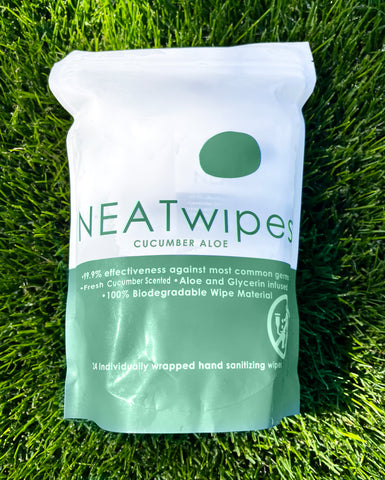 A pouch of NEATwipes Cucumber Aloe on grass.