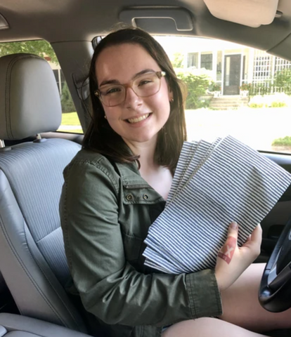 Abby Tutterow, NEATGOODS' summer intern, in her car with NEATsheets.