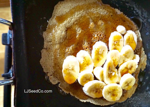 Layer slices of bananas across half of cake with maple syrup all over