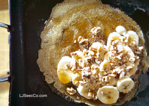 GF pancake with bananas, syrup, and walnuts