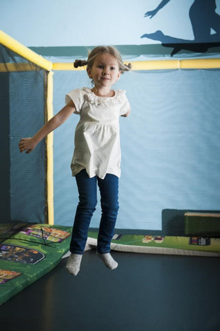 small girl jumping on indoor trampoline