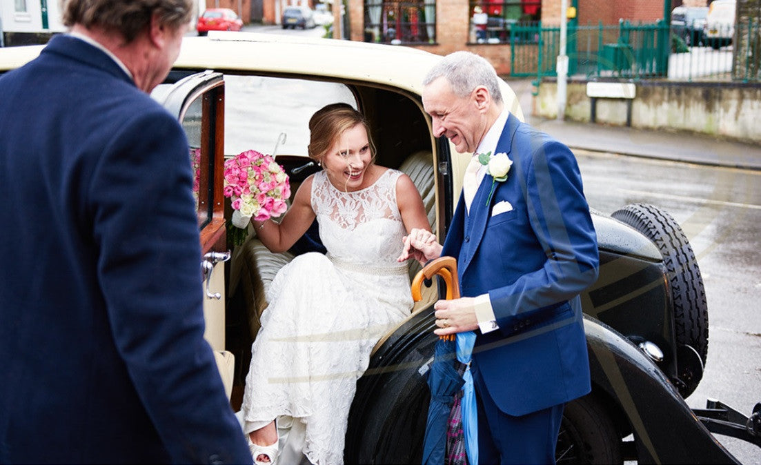 Bride in wedding car with pink Rose bridal bouquet.