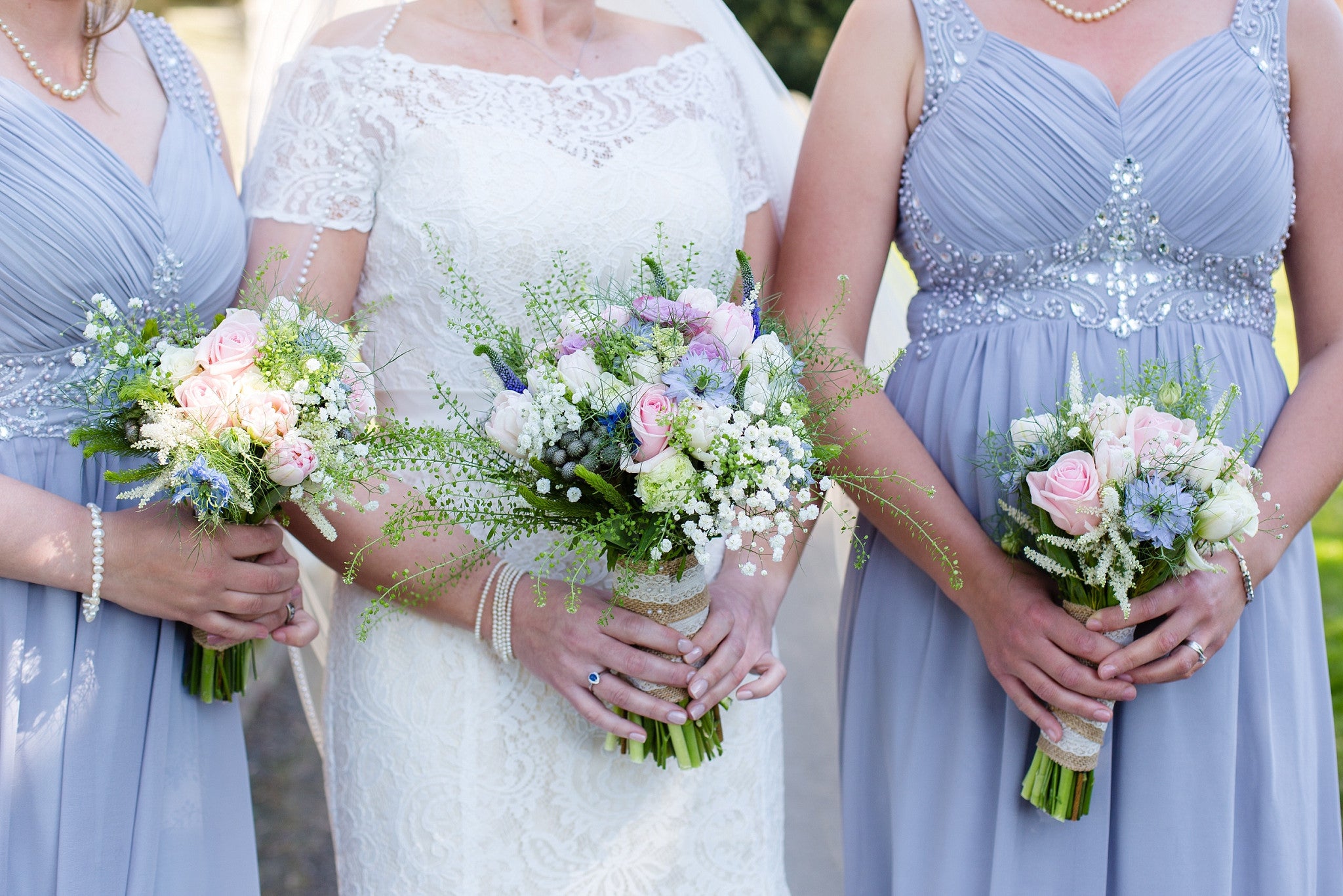Bride and Bridesmaid's with wedding flower bouquets in shades of pink, cream and blue.