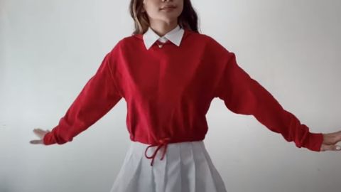 girl wearing red longsleeve shirt with white collar and a skirt