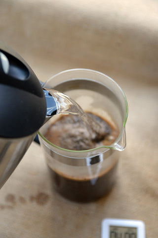 Pour hot water over coffee grounds in French press