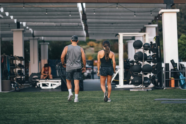 man and woman leaving the gym after weight lifting