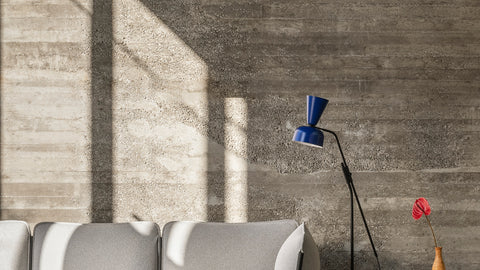 An Alphabeta Floor Lamp in Blue stands next to a Kumo Sofa in Porcelain.