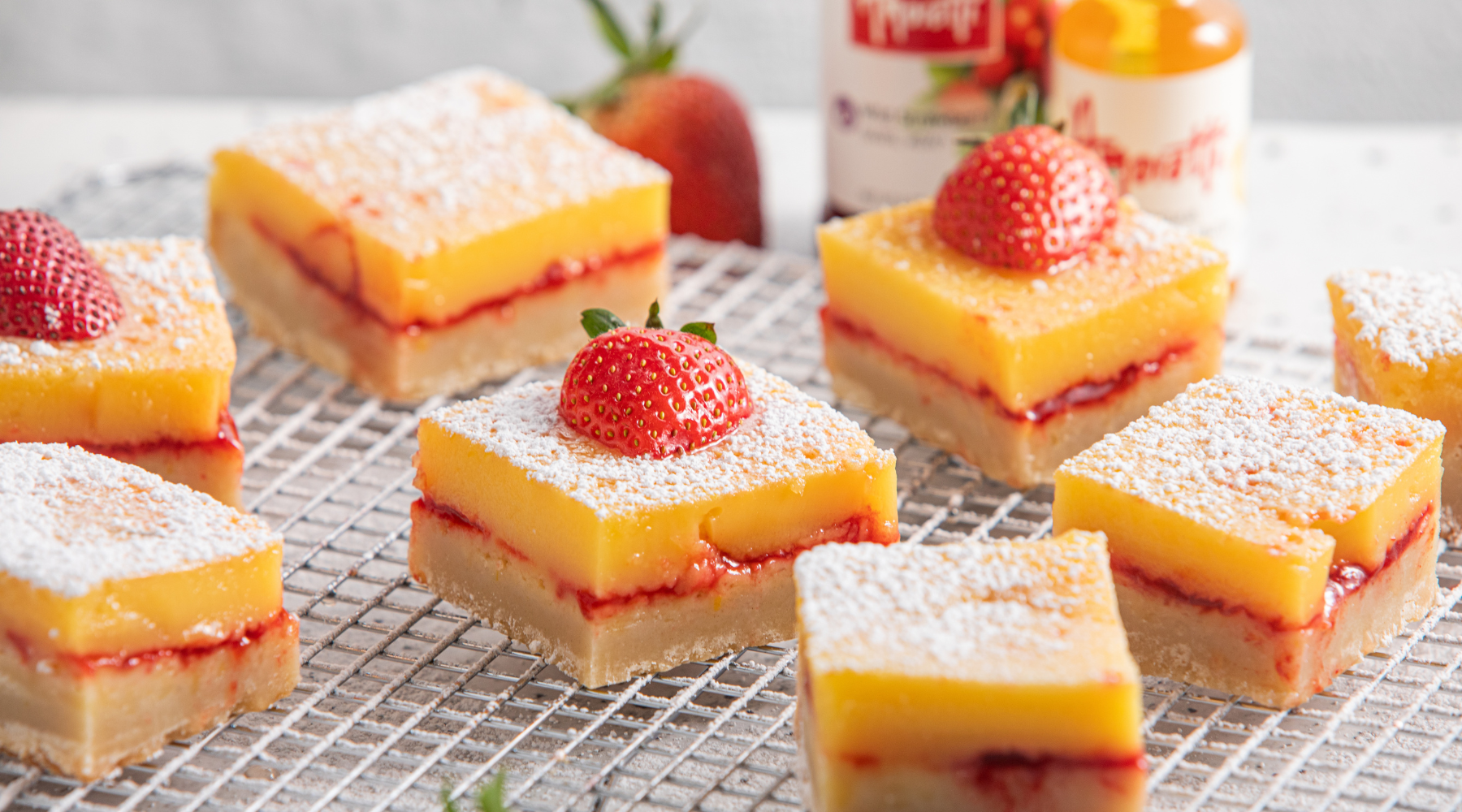 Strawberry Lemon Bars topped with powdered sugar and strawberries