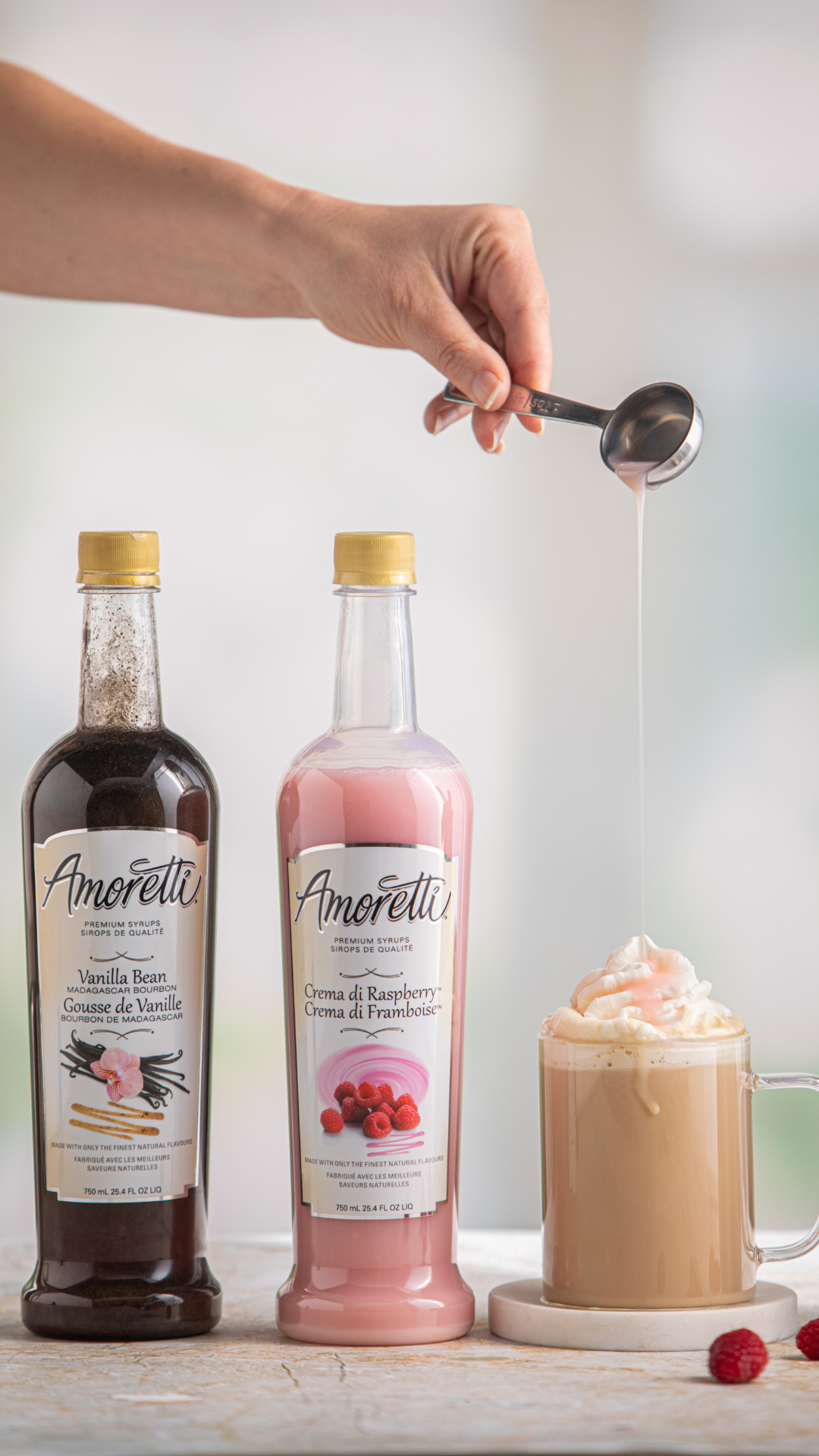 Amoretti Crema di Raspberry being drizzled on top of a Raspberries and Cream Latte