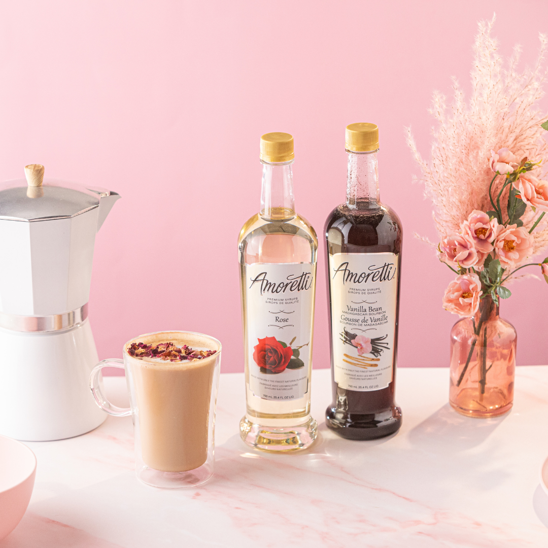 Rose Latte next to Amoretti Premium Rose Syrup and Amoretti Premium Madagascar Bourbon Vanilla Bean Syrup