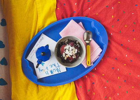 a tray with breakfast food and a child's card for mother's day brekkie in bed