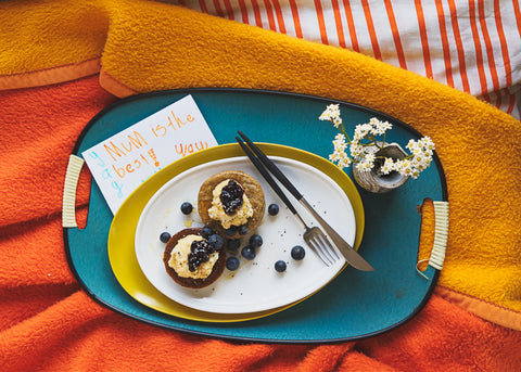 buckwheat pancakes on a tray in bed for mother's day with a child's card for lunch lady magazine