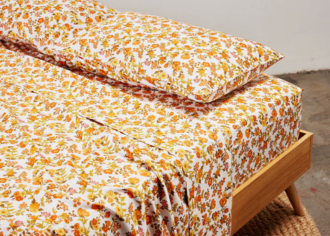 photo of beddie sheets in orange floral pattern on a bed for Lunch Lady magazine