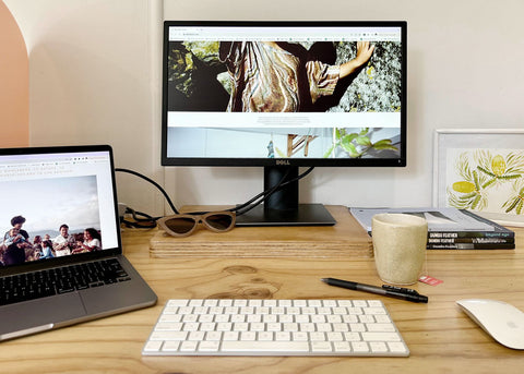 Nat Woods' writing desk with a laptop, keyboard, monitor and mouse.