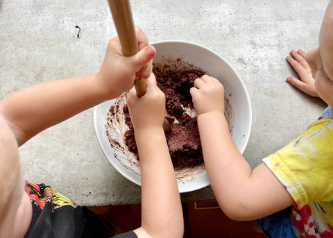 Aerial photo of two toddlers stirring cake mix in a bowl for Lunch Lady magazine