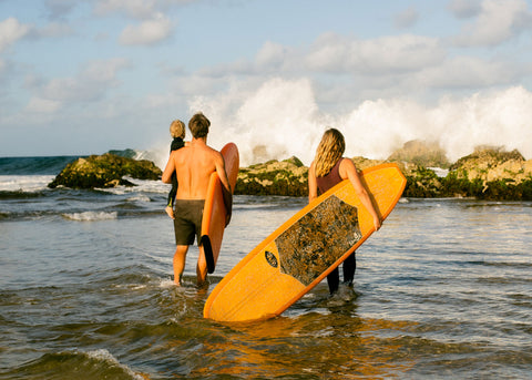 photo of Lauren Hill and family going into the surf for parents who play feature in Hello Lunch Lady Magazine