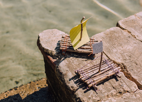 two mini rafts made from sticks with paper sails for Lunch Lady Magazine