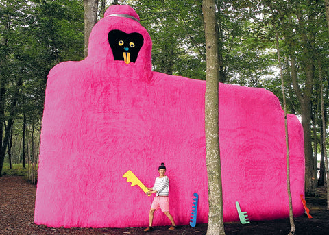 Misaki Kawai stands in front of a giant pink hairy sculpture holding a comb for Lunch Lady Magazine