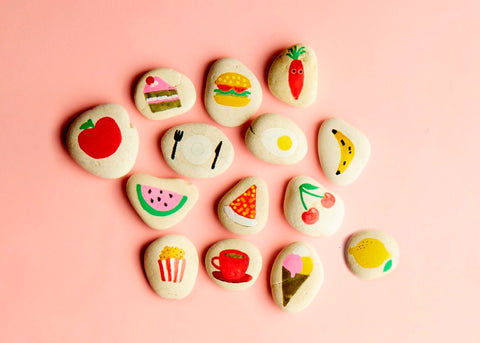 Photo of handmade story stones with food images on them by Beci Orpin for Lunch Lady Magazine