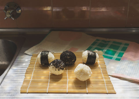 Sushi balls on a bamboo mat for sushi is easy by Lunch Lady Magazine