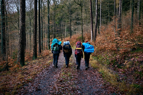 A group of people with backpacks carrying a CampMaid Dutch oven