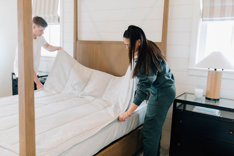 Man and woman making their zipper Beddy's bed.