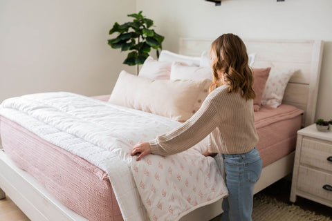 Young girl makes her zipper Beddy's bed.