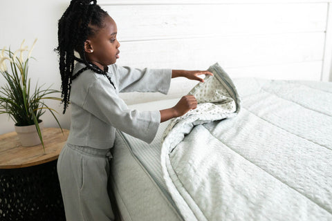 Young girl zips up her zipper Beddy's bedding.