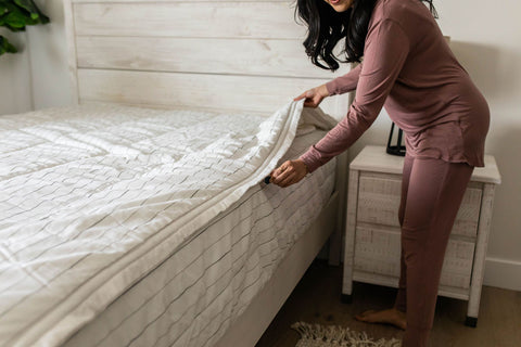 A woman zips up her Beddy's bedding.