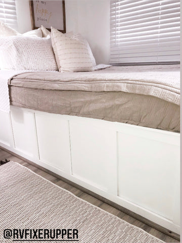 A close up image of the side of a white  RV bed with Beddy's oatmeal colored- Naturally Boho Beddy's on the bed.
