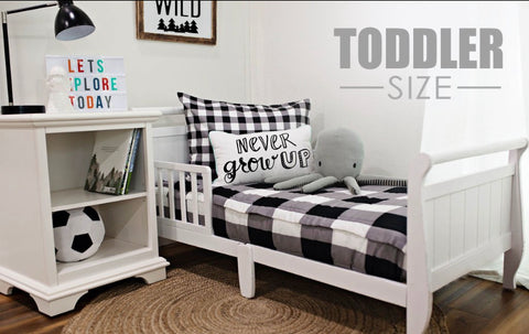 An image of a bedroom featuring a white toddler bed featuring our Checked Out Beddy's.