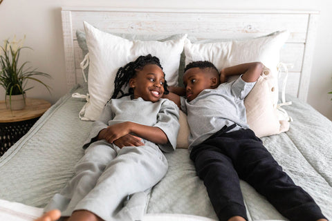 Two kids relax on a bed with Beddy's zipper bedding.