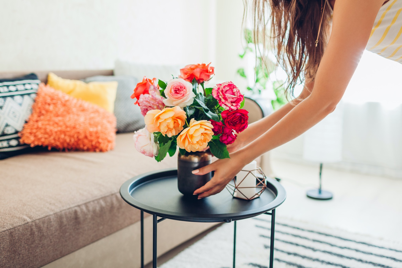 Woman adding fresh flowers to a vase