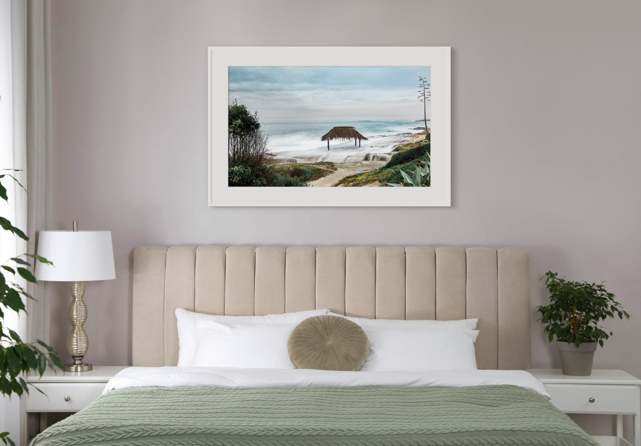 framed coastal art over bed