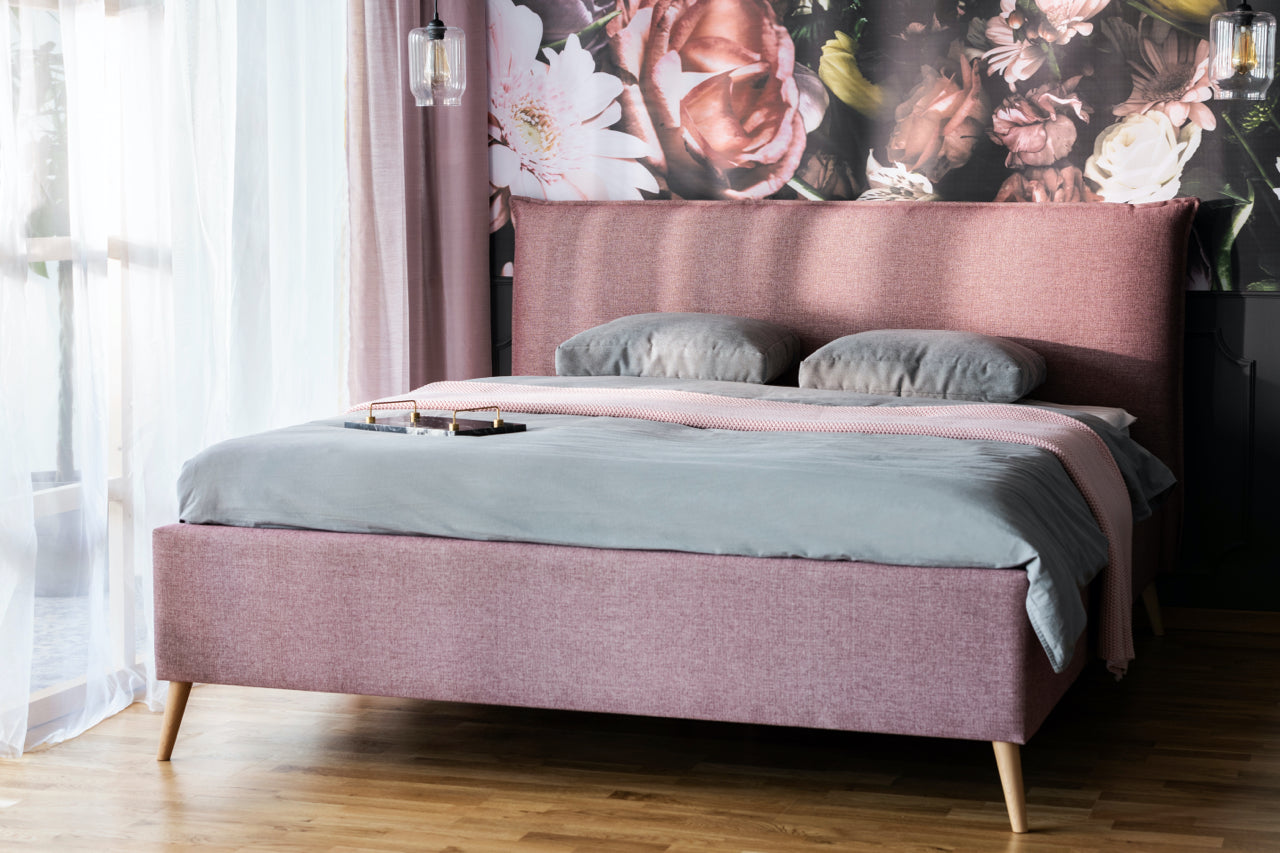 pink bed with floral wallpaper